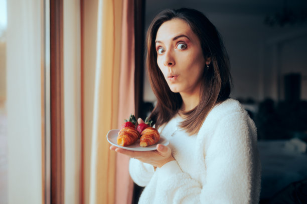 快乐女人早餐吃牛角面包和草莓图片下载