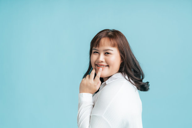 肖像美丽自信的亚洲女性加大小快乐的微笑上孤立的浅蓝色工作室背景。图片下载