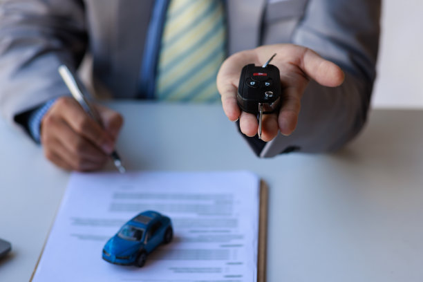 商人之手微笑的汽车推销员递上你的新车钥匙，经销商和销售给汽车钥匙的概念图片下载