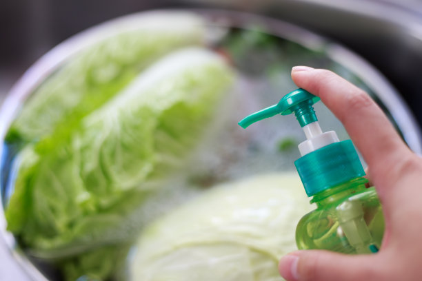 家庭主妇的手压蔬菜清洗液。健康的生活方式摆脱有毒的化学食物。女性手拿着水果和蔬菜清洁瓶放在水槽上图片下载