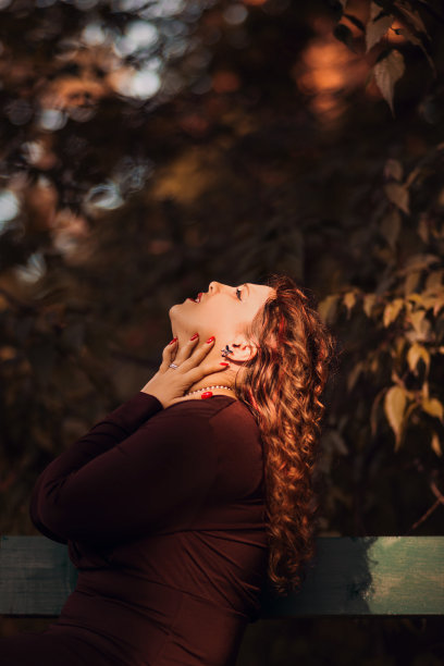 年轻女子的侧影，在秋天的公园和抬头图片下载