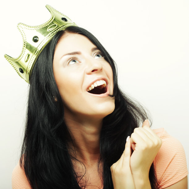 快乐的年轻可爱的女人与皇冠图片下载