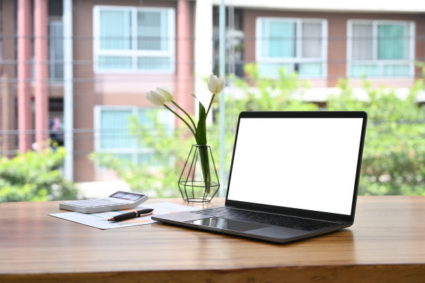 舒适的工作场所，笔记本电脑，咖啡杯和笔记本放在木桌上。图片下载