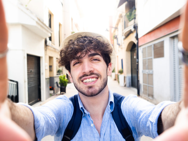 一名年轻游客在城市街道上自拍。旅游,夏天图片下载