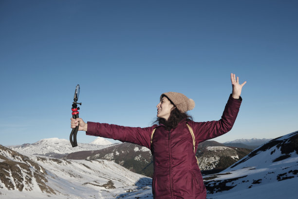 快乐的女性视频博主以雪山游客的身份录制内容。图片下载