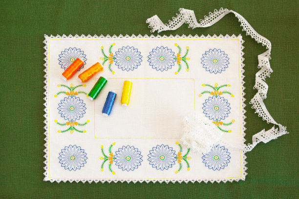 绣有矢车菊和线轴的餐巾，上面有刺绣和花边。刺绣作为一种创造性和针线活。图片下载
