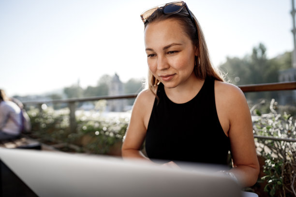 年轻的金发女商人在伊斯坦布尔的露台上使用笔记本电脑工作图片下载