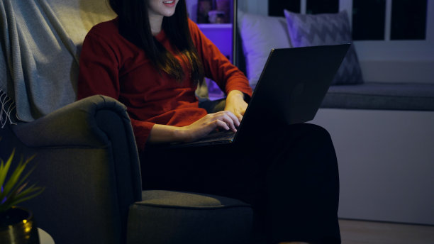 亚洲女性晚上在家用笔记本电脑看电影。放松休闲的生活方式。图片下载