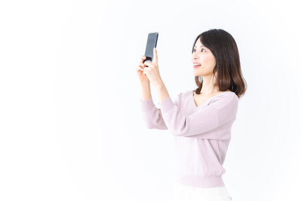年轻女子用智能手机拍了一张微笑的照片图片下载