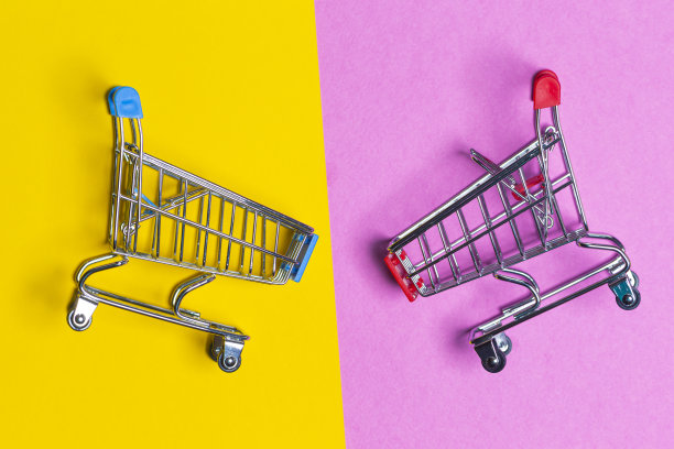 销售的概念。两个空推车设计购物或销售推车放置在混合潮流黄色和粉红色的背景与文字空间。图片下载