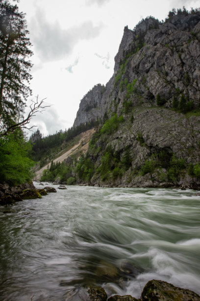 在奥地利中部的阿德蒙特镇附近的Gesause国家公园，多云的天气下，古老的绿色铁路桥旁的水流越过狂野的恩斯河。长时间曝光的照片图片下载