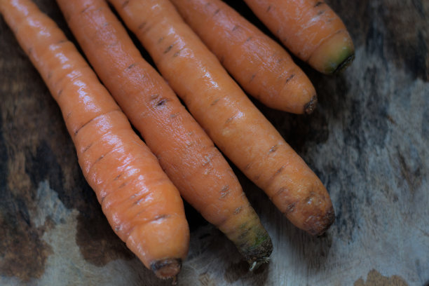 从花园里洗好的胡萝卜放在木制表面，自然光。图片下载