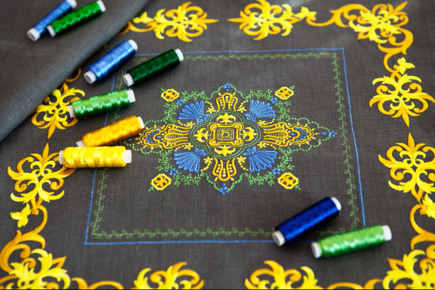 靠垫套上有漂亮、别致的黄色刺绣。顶部是相同配色的线轴。图片下载