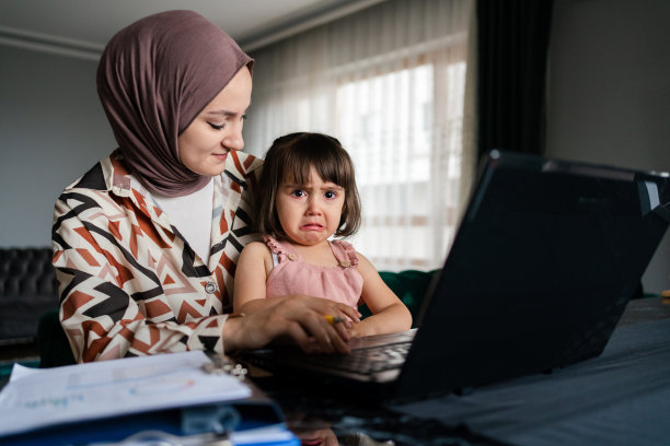 中东母亲在家带孩子工作图片下载