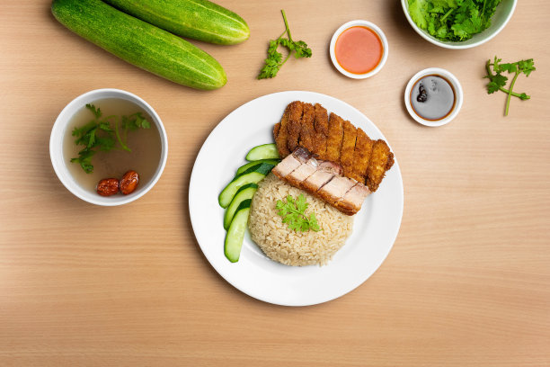 鸡排和烤猪肉饭与生黄瓜，香菜，沙拉，酱汁和汤在一个盘子孤立在木制背景俯视图图片下载