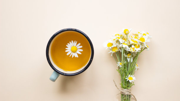 草本洋甘菊茶在杯与白色洋甘菊花和雏菊花束淡米色的背景。平层,顶部视图。替代、互补、传统医学。免疫预防健康图片下载