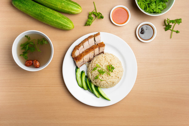 烤猪肉饭，生黄瓜，香菜，沙拉，酱汁和汤，在一个盘子孤立的木制背景俯视图图片下载