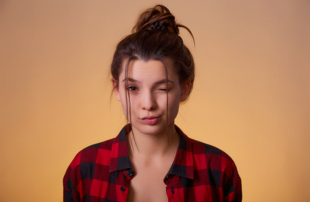 特写的俏皮和甜蜜的女人显示鸭脸和给眼睛孤立的黄色背景与文本拷贝空间的肖像图片下载