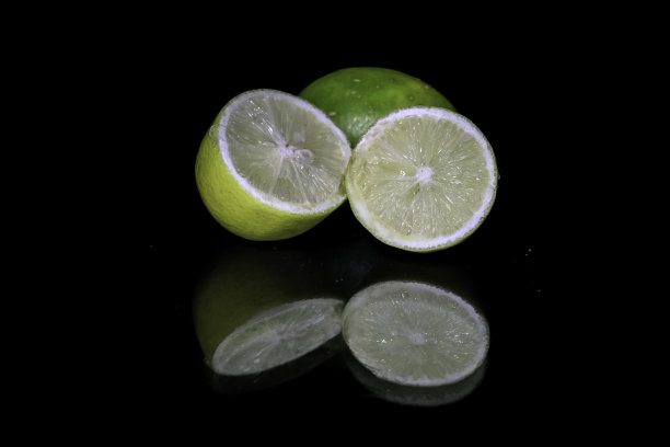 黄色柠檬片孤立在黑色背景微距近距离反射图片下载