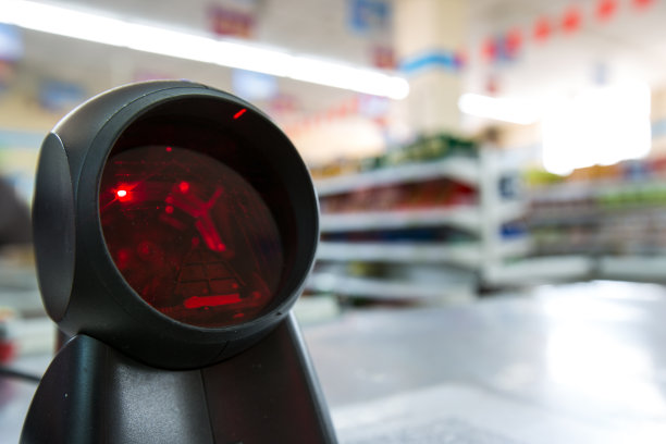 终端设备的商品扫描和模糊超市背景图片下载