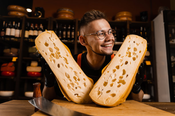 情感奶酪侍酒师正享受着自然陈酿的限量maasdam奶酪。奶酪食品广告图片创意。图片下载