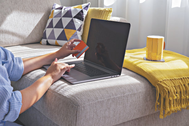 女性用信用卡在网上购物时使用笔记本电脑。黑色星期五和网络星期一的概念图片下载