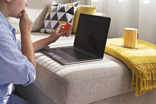 一位女士在网上购物时使用笔记本电脑使用信用卡。黑色星期五和网络星期一的概念图片下载