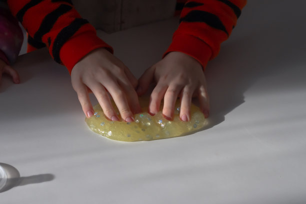 孩子用手指咔哒咔哒地捏着黄色柔软的黏液图片下载