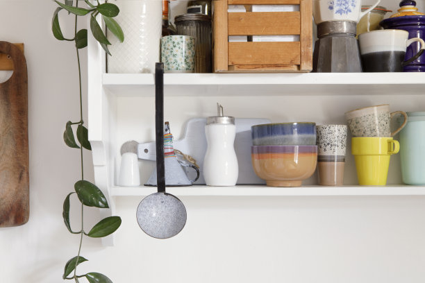 复古风格的厨房木制货架与厨房用具。储物柜是开放式的，厨房的架子上放着陶瓷陶器。一套色彩鲜艳的盘子在现代室内，家居装饰。图片下载