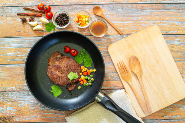 意大利经典肉酱肉酱是碎牛肉配上番茄、橄榄油、大蒜和迷迭香，放在平底锅上，深色木质底子上放上新鲜的罗勒，平放图片下载
