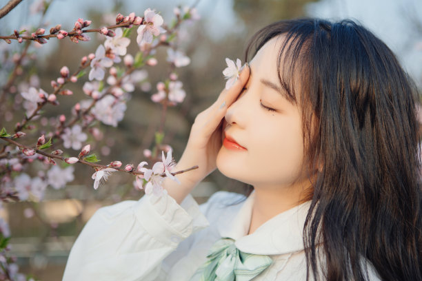 美丽的女孩在公园里欣赏鲜花图片下载