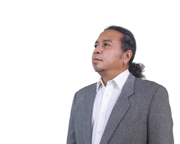 一个穿着西装的男人站在白色背景下，看着别处。图片下载