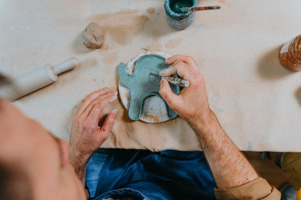 年轻人用粘土工作的特写图片下载