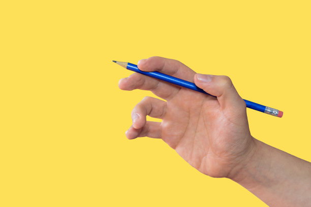 白色的手拿着黄色背景上的蓝色铅笔图片下载