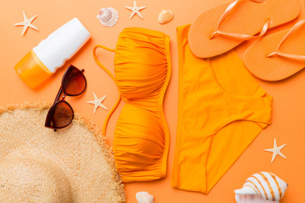 女子泳装和海滩配件平铺顶视彩色背景夏季旅行的概念。比基尼泳装，草帽和高跟鞋。复制空间俯视图图片下载