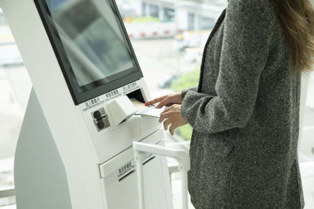 一位年轻的女士正在柜台办理自助登机手续图片下载