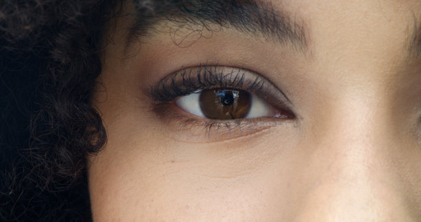 健康的眼部护理，清晰的视觉。特写的脸，眼睛和眉毛的一个女人向前看。放大肖像头像的女人盯着前方与美丽的棕色眼睛图片下载