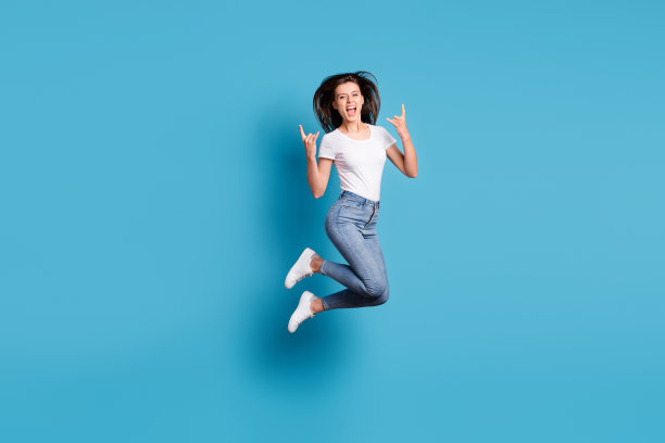 疯狂时髦的女人跳起来的全尺寸照片使摇滚标志音乐爱好者孤立在蓝色背景上图片下载