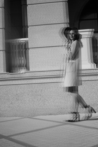 一个年轻女孩在城市里行走的黑白照片。图片下载