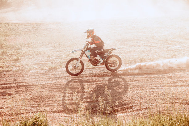 现场拍摄男运动员在炎热的夏天在户外骑摩托车训练。运动中的越野摩托车手。越野赛运动图片下载