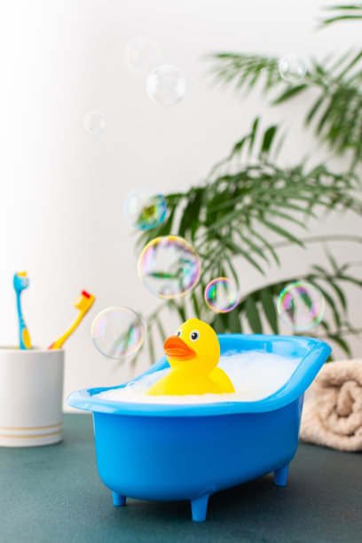 鸭子坐在带肥皂泡沫的洋娃娃浴盆里图片下载