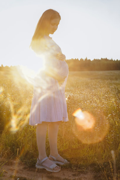 孕妇，腹部特写，背景是野地。图片下载