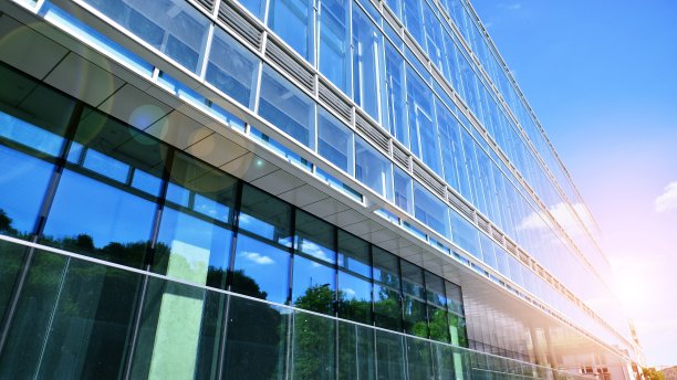 清澈的天空背景下的玻璃幕墙的现代办公大楼。图片下载