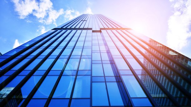 清澈的天空背景下的玻璃幕墙的现代办公大楼。图片下载