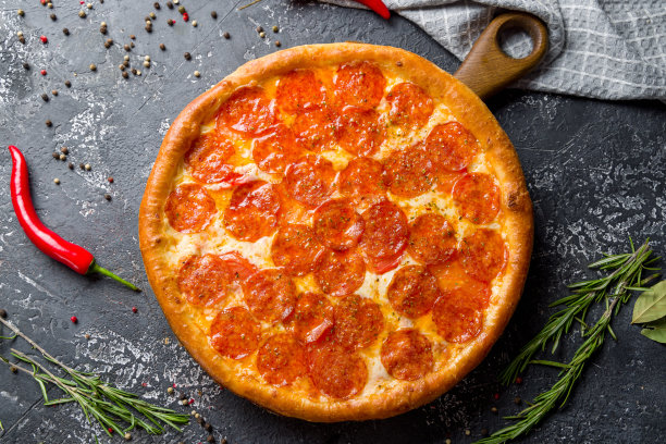 意大利辣香肠披萨在黑石桌上俯瞰图片下载