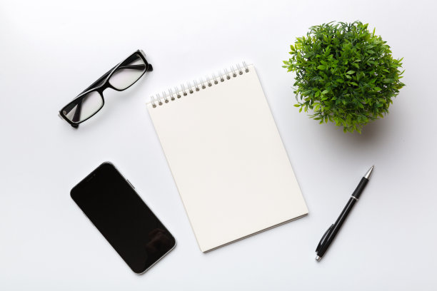 浅色背景笔记本的智能手机。俯视图图片下载