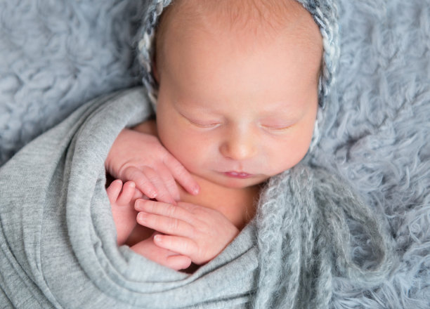 刚出生的婴儿裹着灰围巾睡觉图片下载