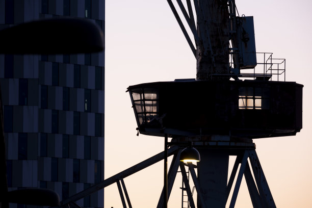 夕阳下一座旧船厂起重机的剪影图片下载