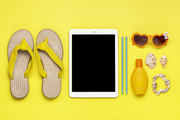 游泳配件-时髦的沙滩人字拖，橙色心形眼镜，贝壳，白色平板，防晒霜在黄色背景平铺俯视图夏天，旅行，聚会，度假的概念图片下载