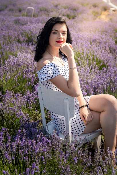 美丽的黑发女子与红色唇膏在薰衣草田摆姿势图片下载